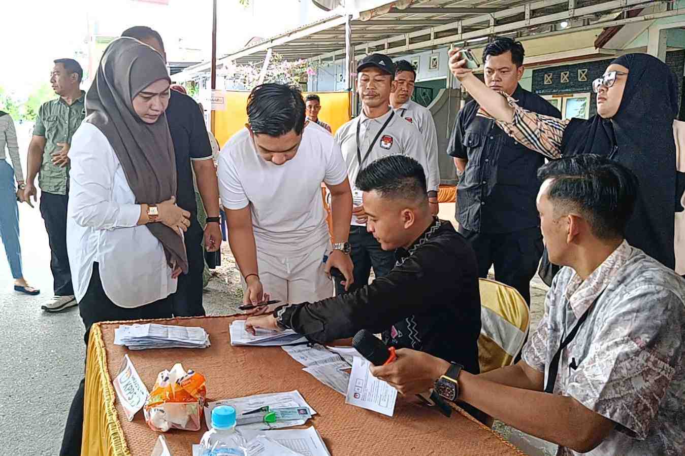 JADI SOROTAN: Lisa Halaby didampingi suami dan putranya mencoblos di TPS 026 Sungai Besar, Banjarbaru (27/11).