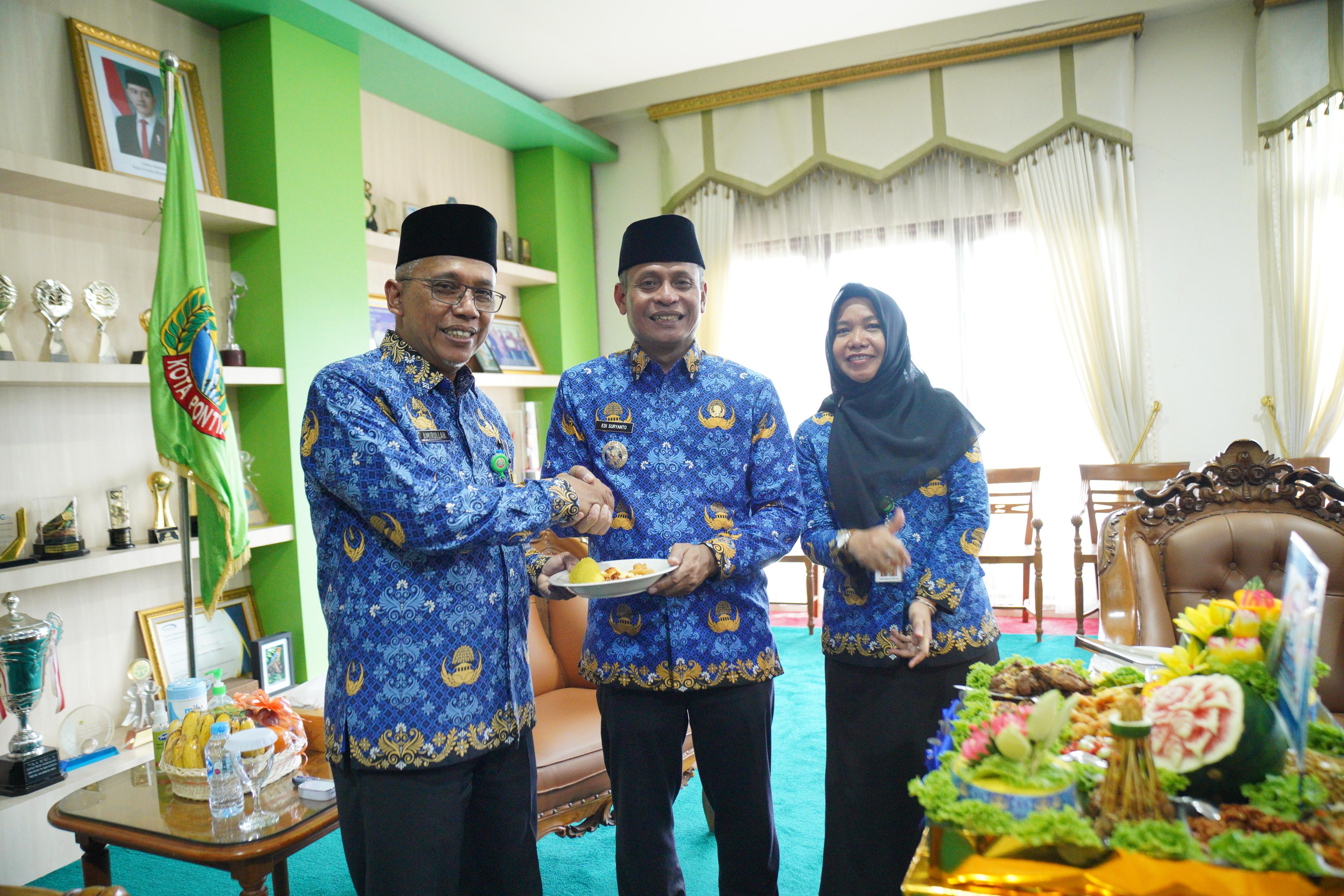 POTONGAN: Pj Wali Kota Edi Suryanto menyerahkan potongan tumpeng kepada Sekda Kota Pontianak Amirullah.