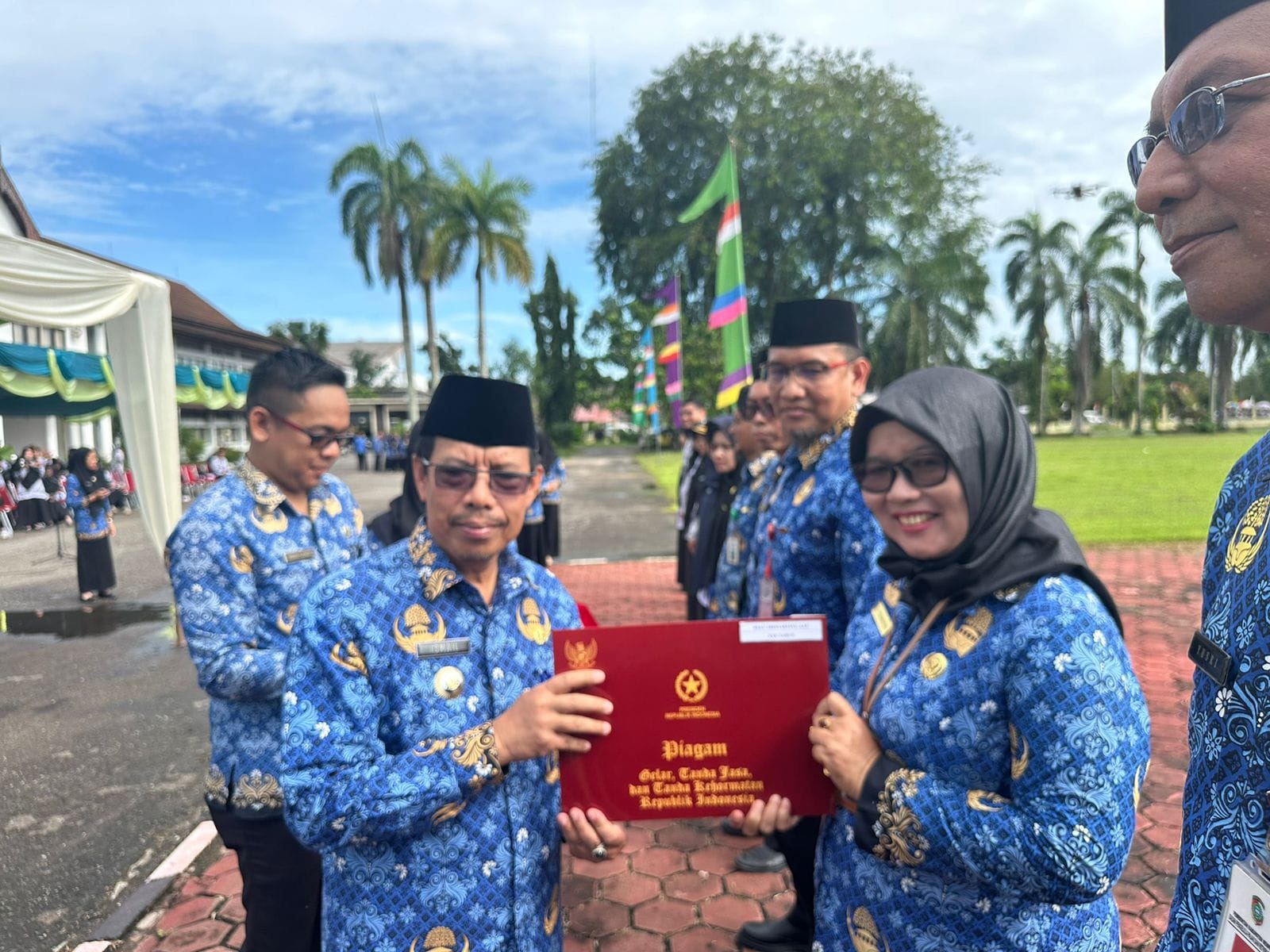 PENGHARGAAN : Pj Bupati Ismail memberikan penghargaan usai upacara HUT KORPRI dan PGRI.
