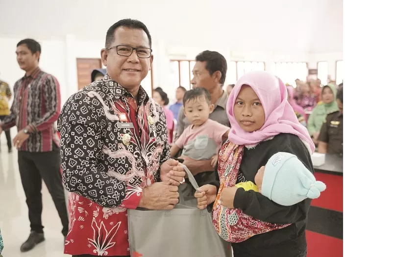 PAKET: Pj Bupati Sanggau, Suherman menyerahan paket makanan gizi tambahan kepada para orang tua guna mencegah risiko stunting pada anak di Sanggau, beberapa waktu lalu.