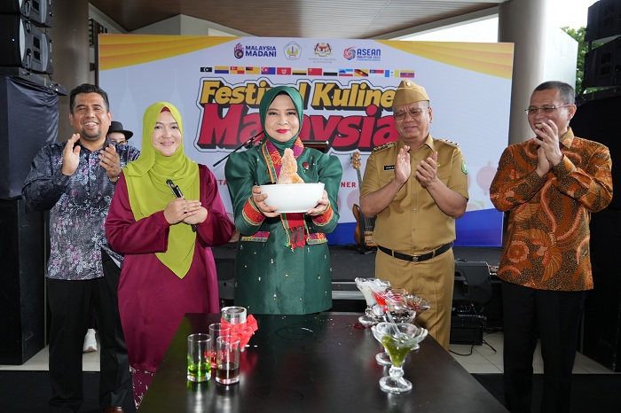KULINER: Windy Prihastari mengangkat es kacang khas Malaysia tanda dibukanya Festival Kuliner Malaysia yang digelar di&nbsp;Gedung Konferensi&nbsp;Untan,&nbsp;Selasa (3/12).