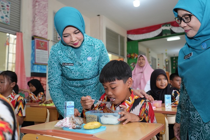 MAKAN&nbsp;: Pj Ketua TP-PKK Kalbar Windy mendampingi salah satu anak saat uji coba makan bergizi gratis di SDN 05 Mempawah, Rabu (4/12).&nbsp;
