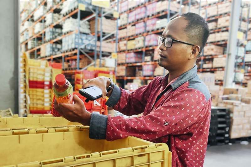 Salah seorang karyawan penyandang disabilitas sedang bekerja di Alfamart.