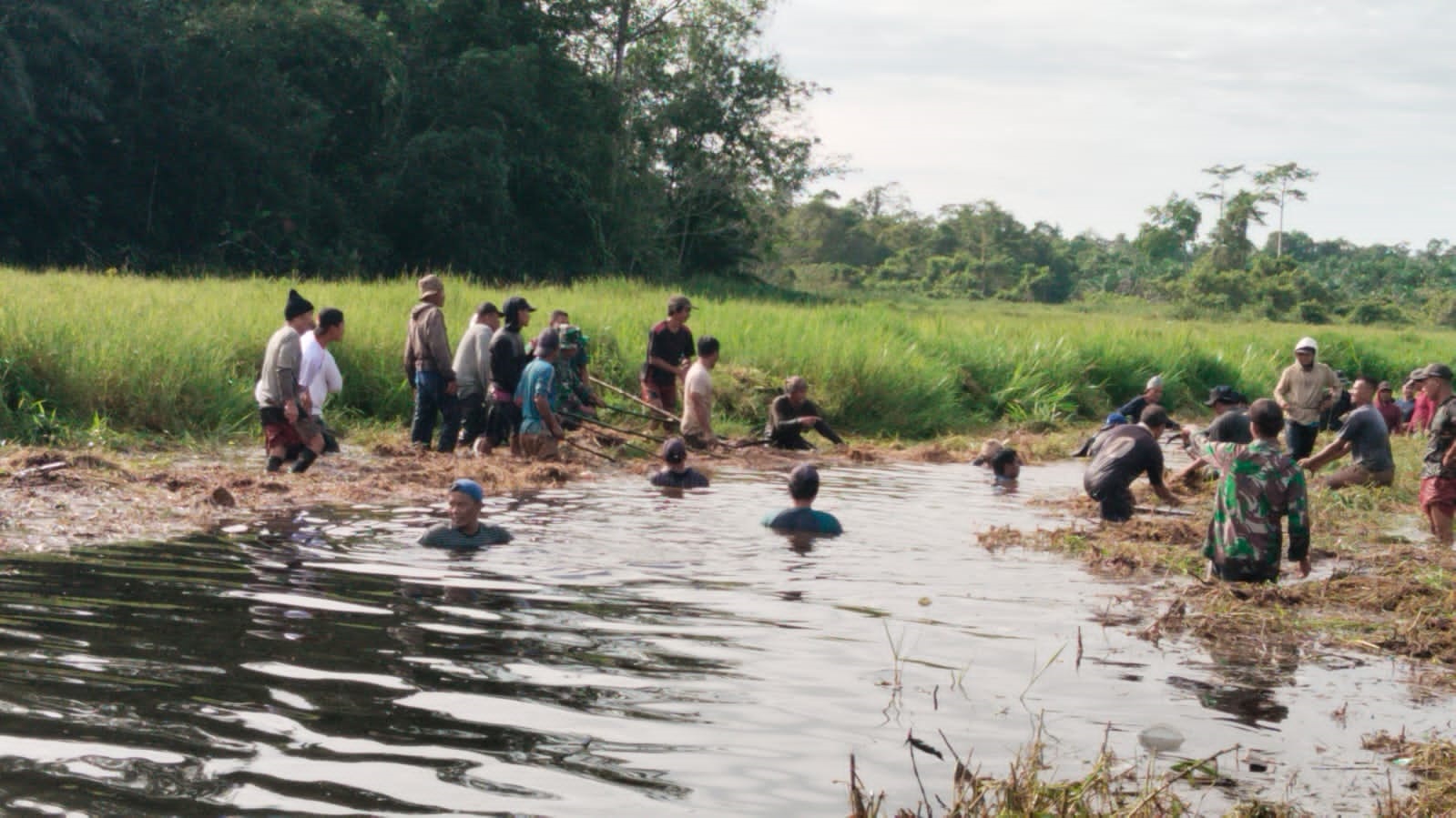 GOTONG ROYONG: Anggota Babinsa Koramil 03/Mandor Jajaran Kodim 1210/Landak, bersama masyarakat melaksanakan karya bakti pembersihan parit di Desa Pongok, Dusun Simpang Pongok, Kecamatan Mandor.