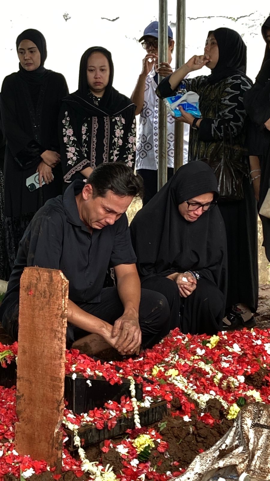 BERDUKA: Andhika Pratama dan Ussy Sulistiawaty di pusara sang ibunda, TPU Jeruk Purut, Jakarta, kemarin (10/12).