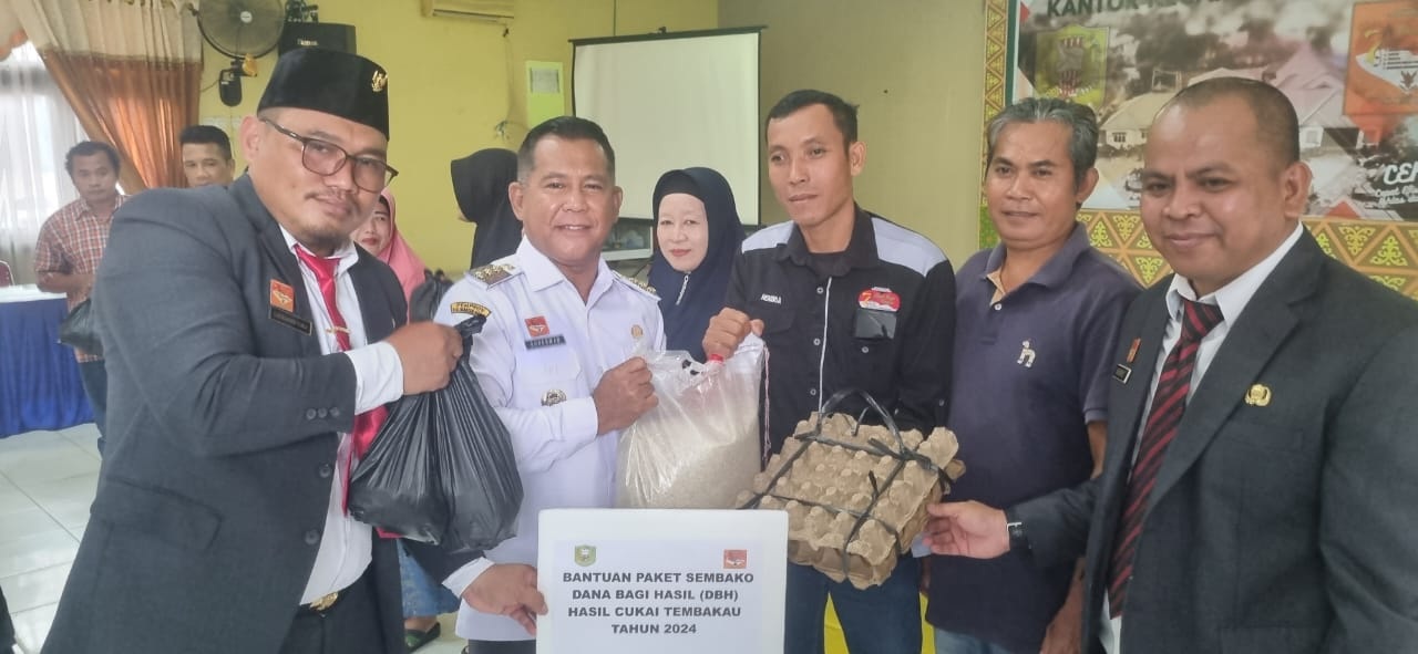 SEMBAKO : Penjabat Bupati Sanggau didampingi Plt Kepala Dinsos P3AKB, dan Camat Kapuas menyerahkan paket Sembako kepada para RT dan Kader Posyandu, Rabu (11/12).