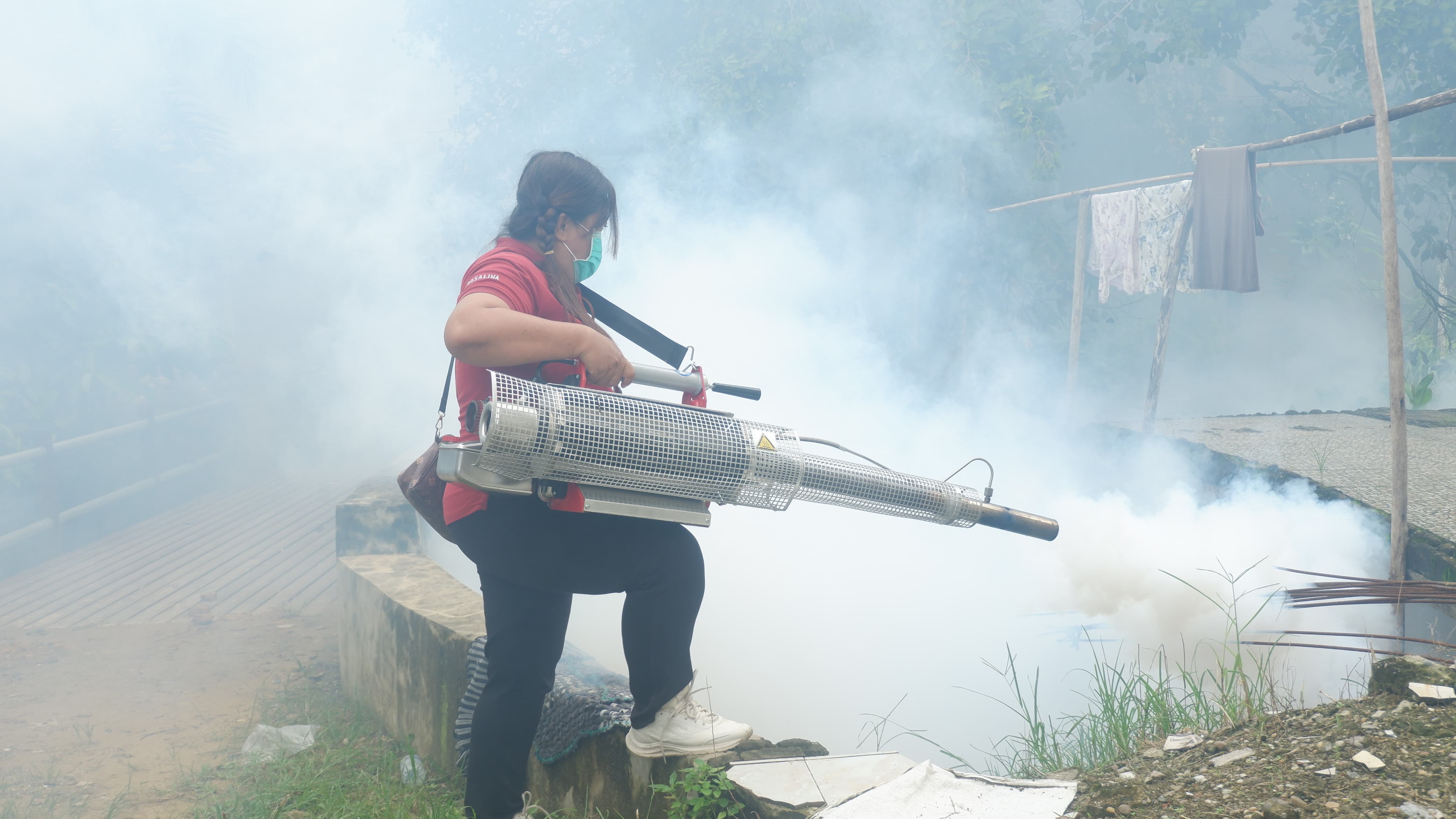 FOGGING: Petugas Puskesmas Ngabang saat melakukan fogging di sekitar pemukiman warga di Desa Hilir Kantor.