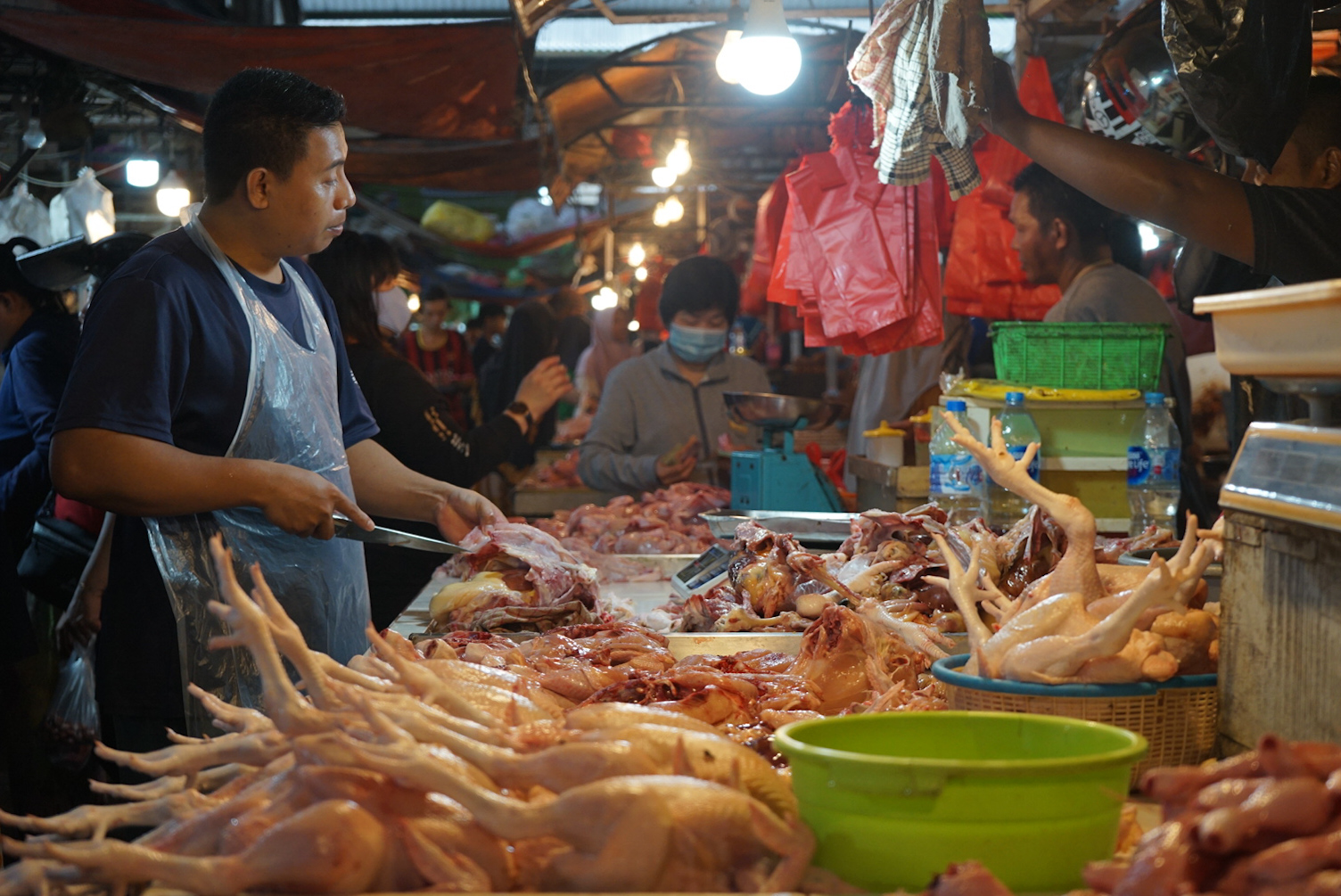 HARGA AYAM: Pedagang ayam daging sedang memotong ayam untuk disiapkan dijual kepada pembeli di Pasar Flamboyan.