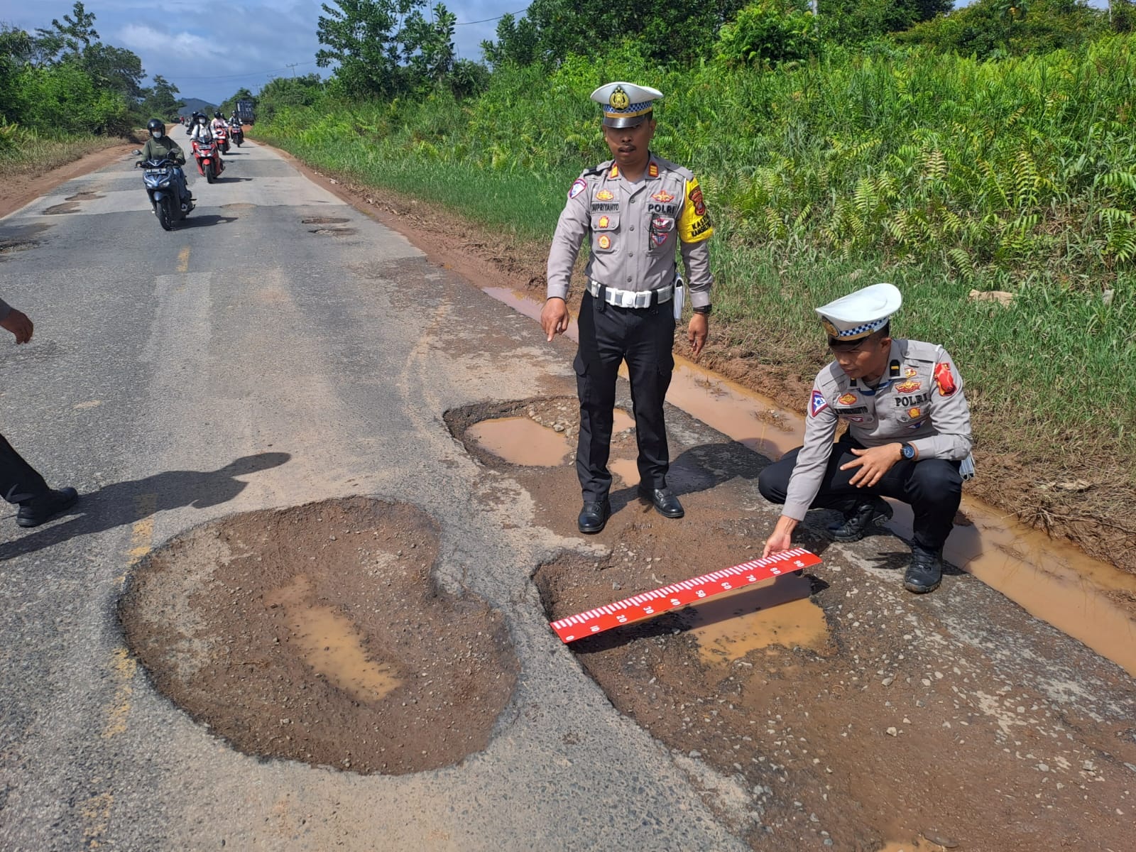 PERBAIKAN: Personel Polres Kubu Raya melakukan perbaikan dan menutup sejumlah lubang di ruas Jalan Trans Kalimantan, tepatnya di KM 36 hingga KM 41, Desa Teluk Bakung, Kecamatan Sungai Ambawang.