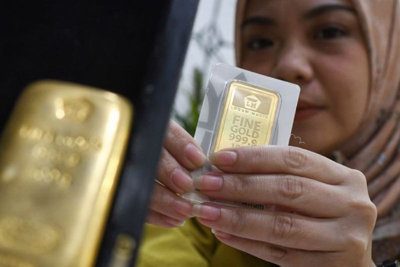 Petugas menunjukkan emas batangan di Butik Emas Logam Mulia (BELM) Antam Setiabudi, Jakarta, Jumat (12/7/2024).