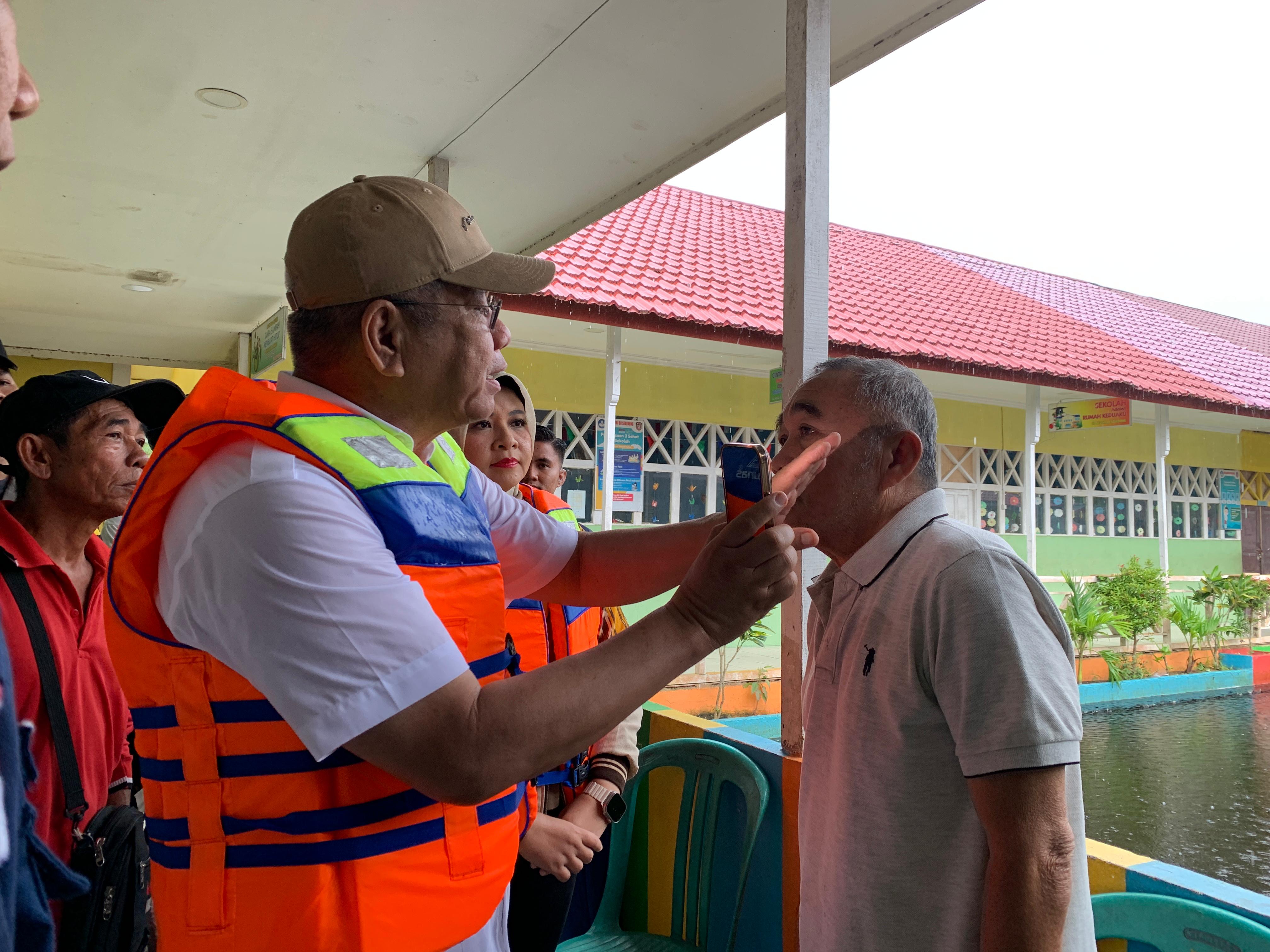 PERIKSA: Pj Gubernur Harisson memeriksa kesehatan salah satu korban banjir di Kabupaten Mempawah saat kunjungan kerja Desember 2024 lalu.