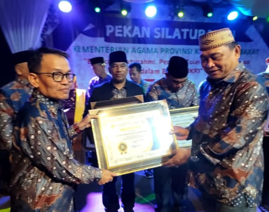 PENGHARGAAN : Kepala Kanwil Kemenag Provinsi Kalbar, H. Muhajirin Yanis menyerahkan penghargaan kepada Kepala Kemenag Singkawang, H. Muhlis.