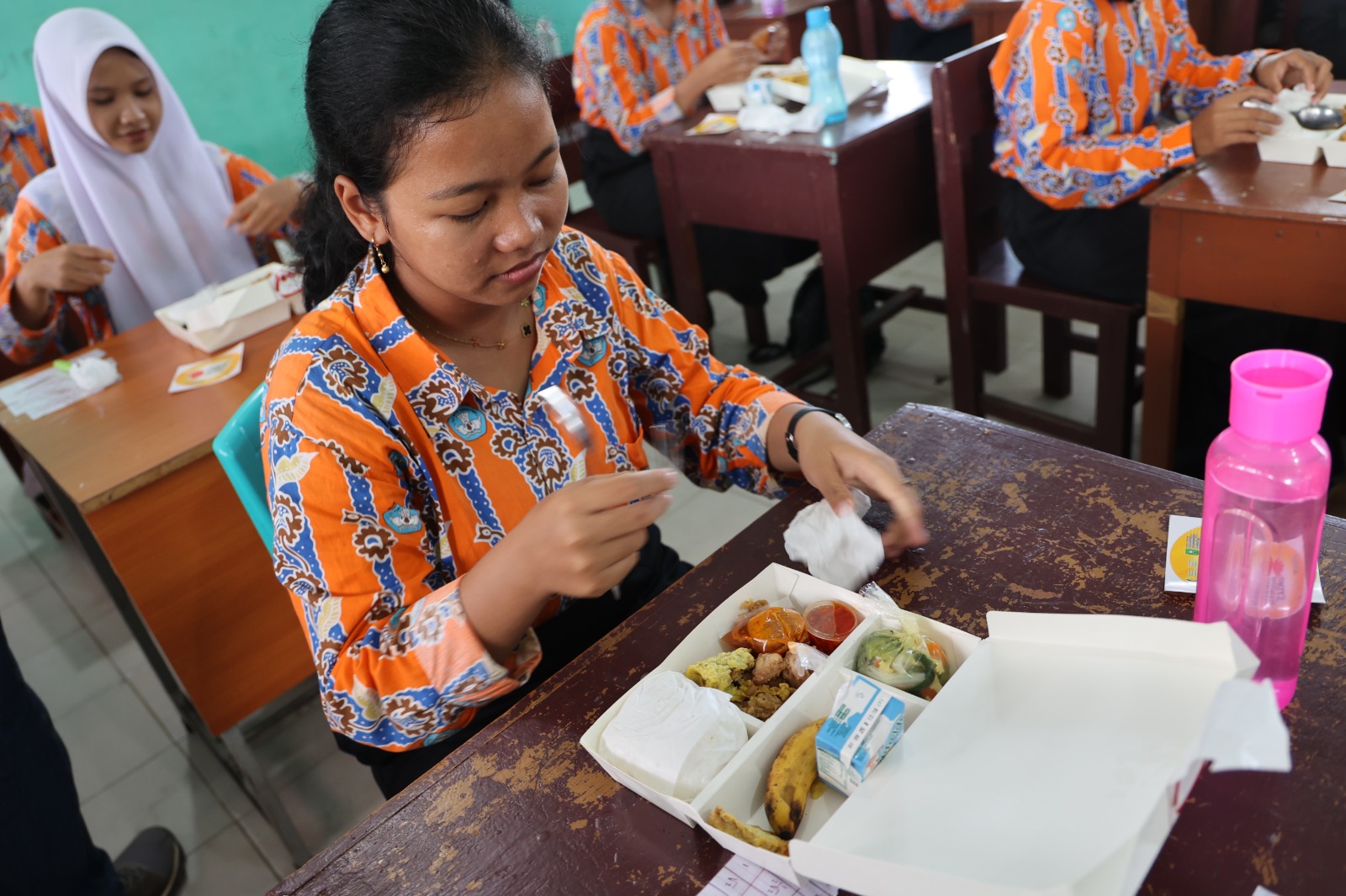 MENYANTAP : Seorang siswa hendak menyantap makanan yang merupakan program Makan Bergizi Gratis yang dilaksanakan oleh Sub Holding PTPN IV PalmCo.