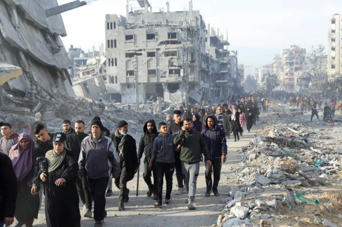 BERJALAN PULANG: Warga Palestina melintasi reruntuhan saat akan kembali ke rumah mereka menyusul gencatan senjata antara kelompok Hamas dan Israel di Jalur Gaza.