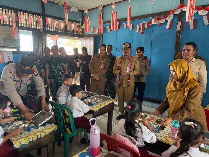 MENINJAU: Penjabat Bupati Landak Gutmen Nainggolan saat meninjau langsung uji coba Makan Bergizi Gratis (MBG) di SDN 09 Ngabang.