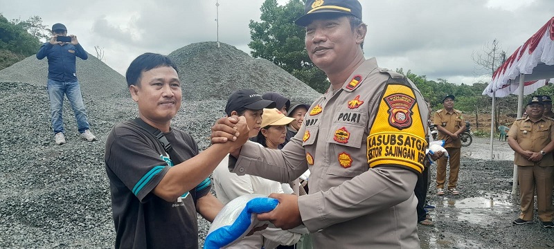 BANTUAN: Wakapolres Sambas, Kompol Hoerrudin menyerahkan bantuan beras kepada masyarakat Dusun Asuansang, Desa Sungai Tengah, Kecamatan Sajingan Besar, Selasa (21/1).