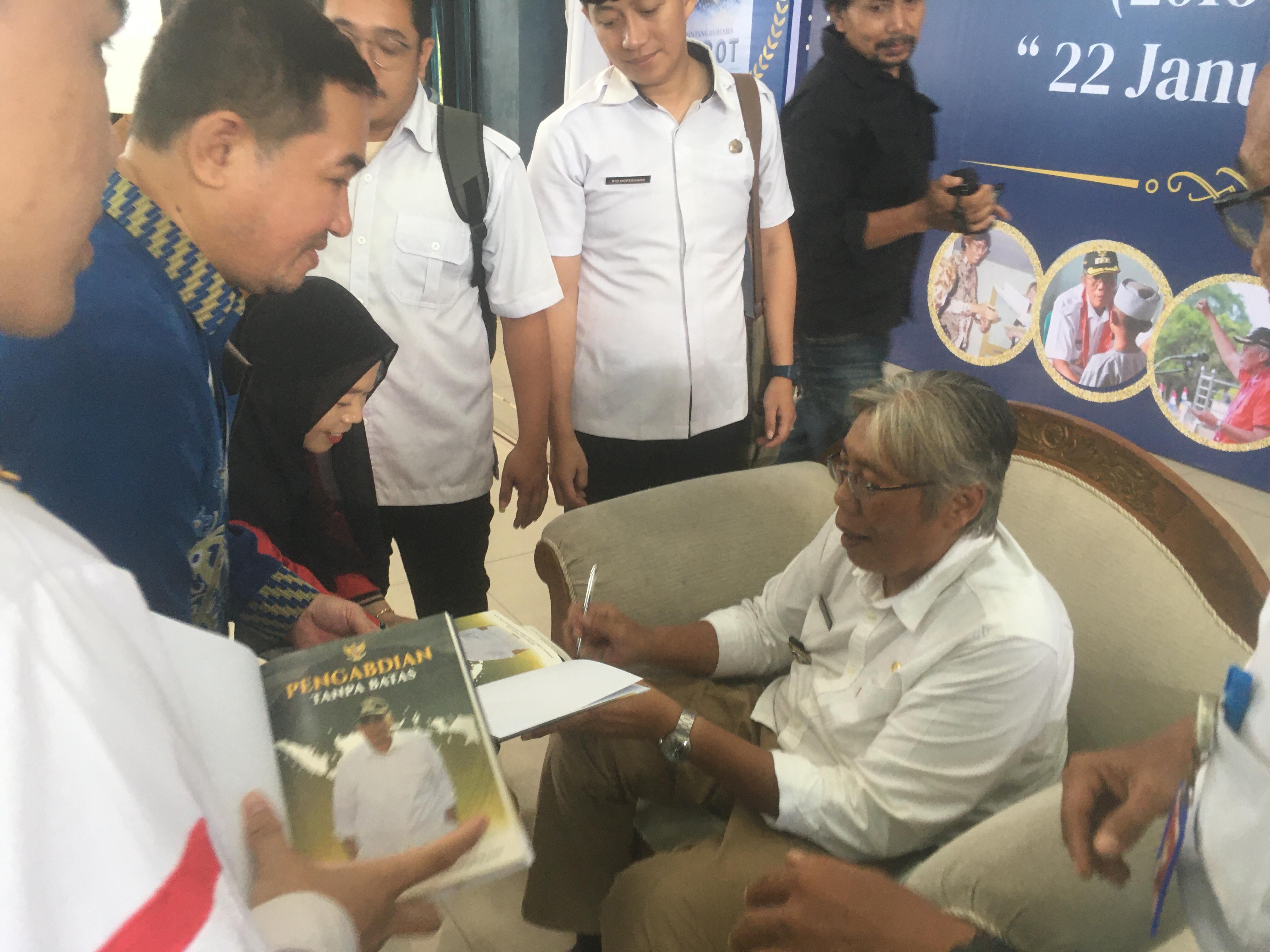 BUKU : Jarot Winarno ketika menandatangani langsung buku yang menceritakan kisah perjalanannya sebagai Bupati Kabupaten Sintang.