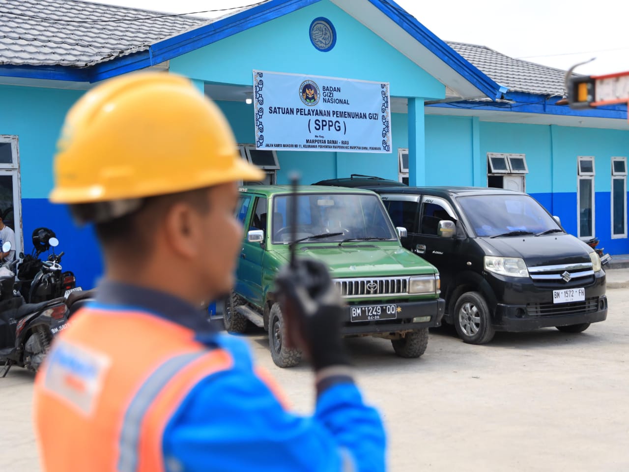 Petugas Pelayanan Teknik (Yantek) tengah berkoordinasi dengan tim teknis melalui Handy Talky saat memastikan kondisi kelistrikan Satuan Pelayanan Pemenuhan Gizi (SPPG).