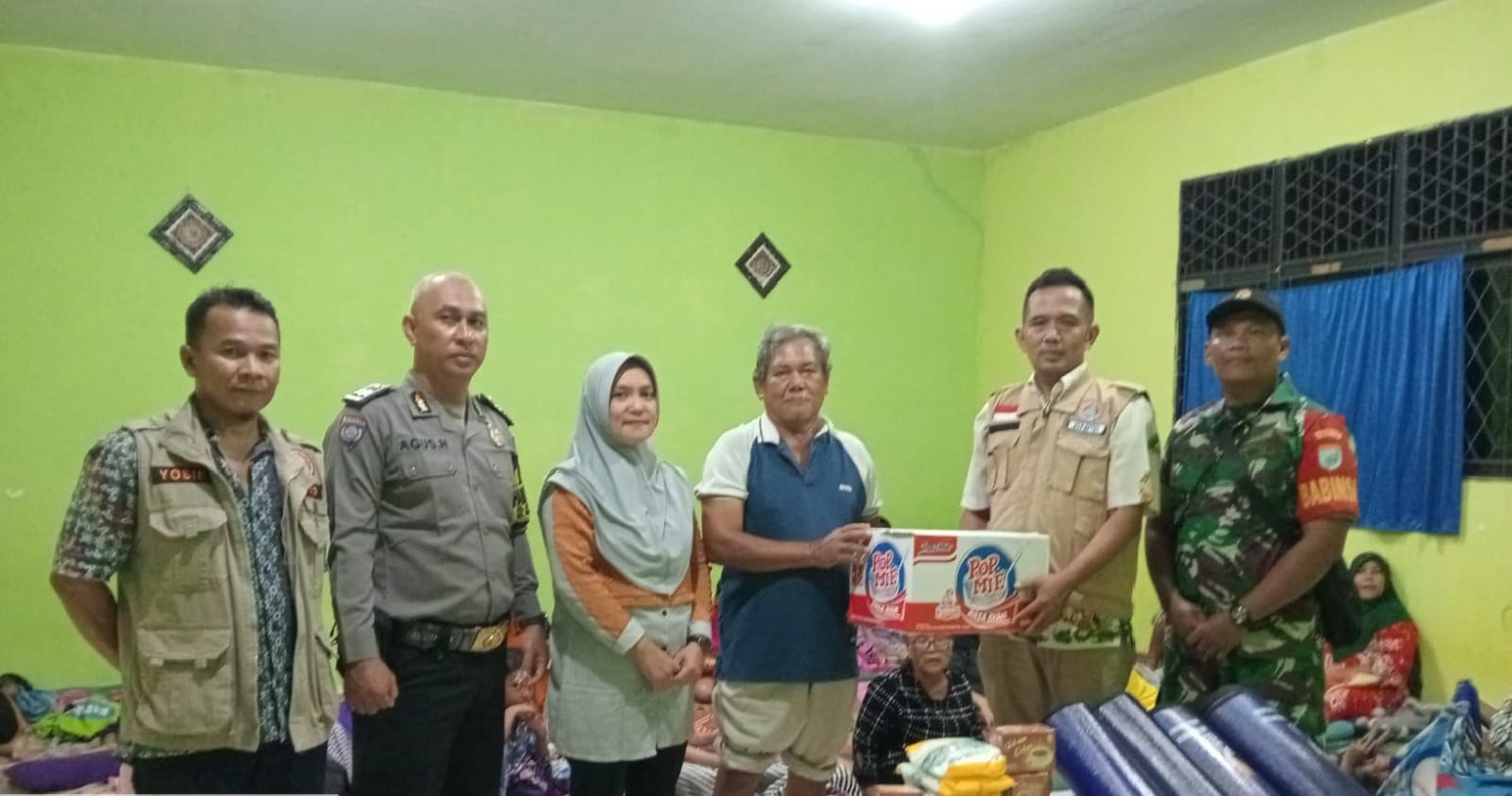 Kepala BPBD Kota Singkawang Nana Priyana, Lurah Setapuk Besar, Kecamatan Singkawang Utara, Lilis Kusianti, serta Babinsa dan Bhabinkamtibmas menyalurkan bantuan kepada korban banjir.