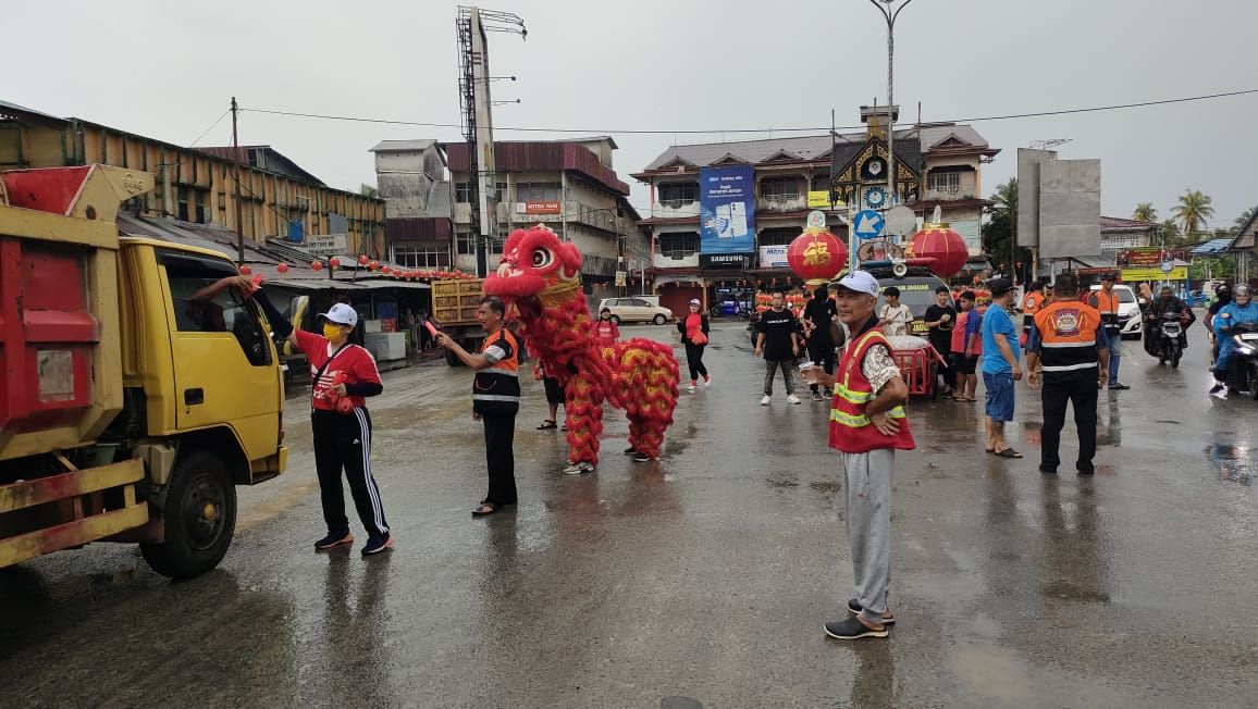 BAGI KUE: Tim Damkar Jaguar saat membagikan 1.000 kue keranjang di Tugu Jam Sungai Pinyuh.