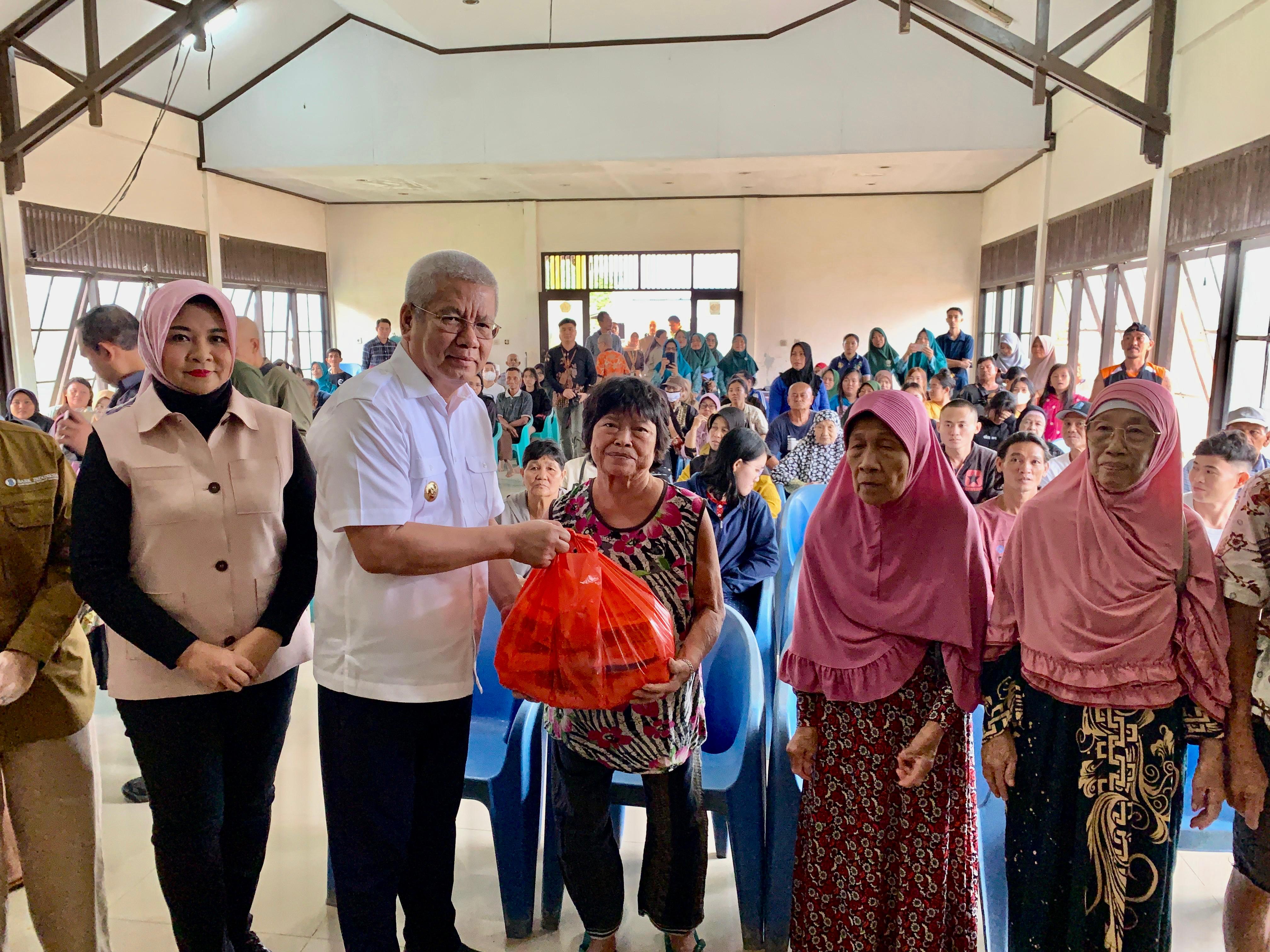 BANTUAN : Pj Gubernur Harisson didampingi Pj Ketua TP-PKK Kalbar dan pejabat terkait lainnya menyerahkan bantuan paket bahan pokok kepada masyarakat Kota Singkawang,