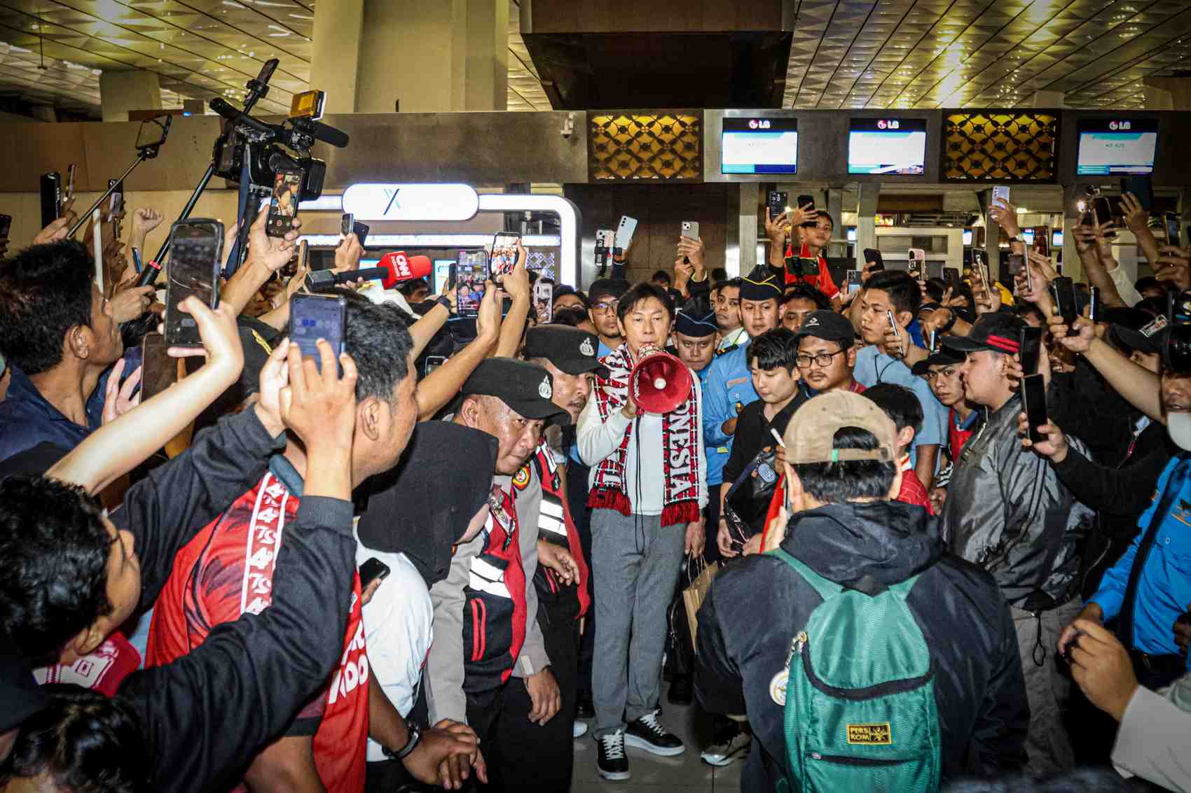 PULANG: Mantan Pelatih timnas Indonesia Shin Tae-Yong (tengah) memberikan sambutan kepada perwakilan suporter Indonesia yang mengantarkan keberangkatannya ke Korsel di Terminal 3.