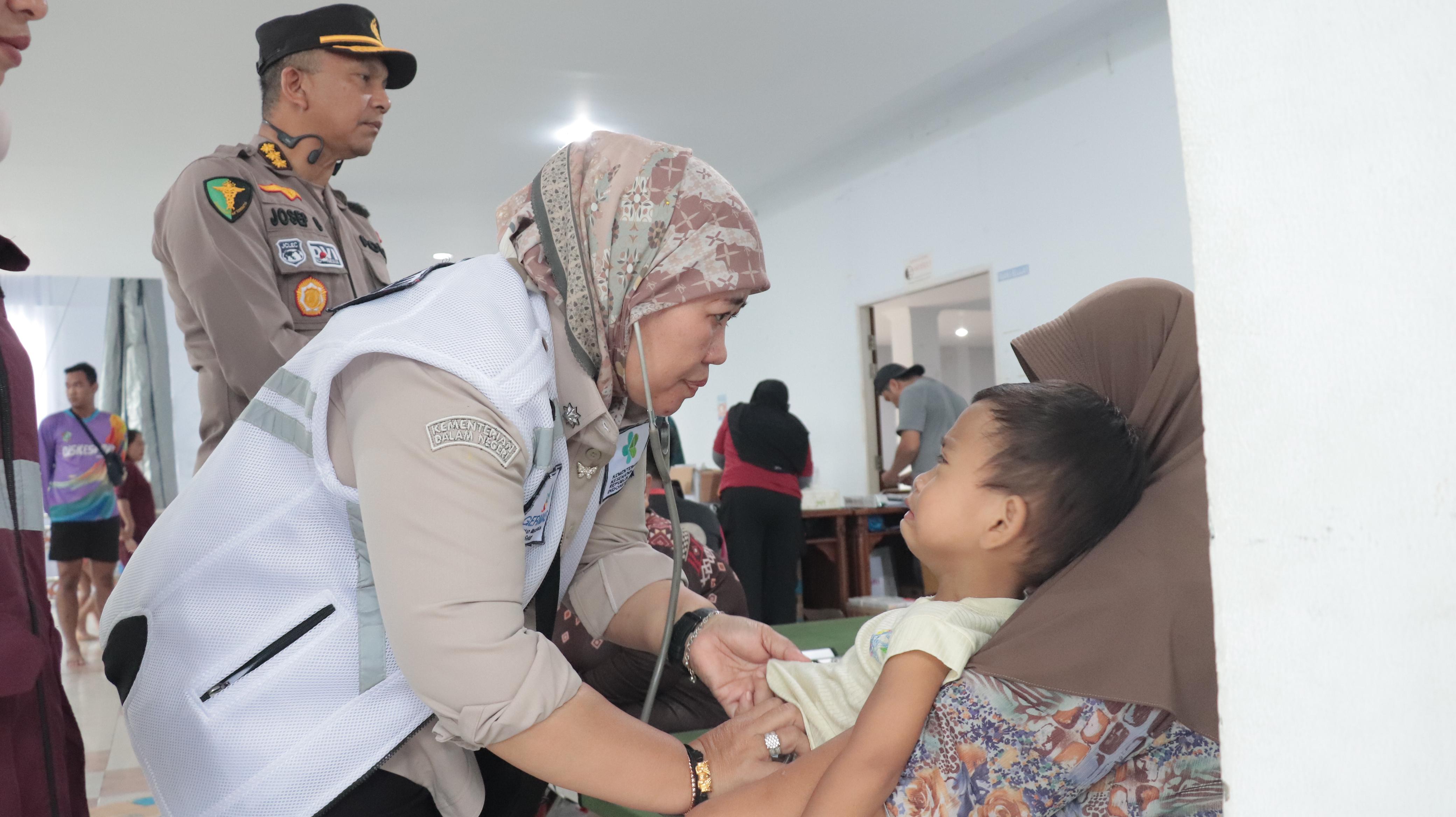 Kadiskes Prov. Kalbar, dr. Erna Yulianti saat memeriksa salah satu anak di Posko pengungsian banjir, di Wisma Chandramidi Mempawah.