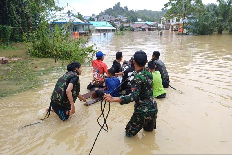 EVAKUASI: Anggota Satgas Pamtas RI bersama BPBD Sanggau dan polisi setempat bekerjasama mengevakuasi sejumlah warga yang terdampak banjir di daerah perbatasan Kalbar-Malaysia.