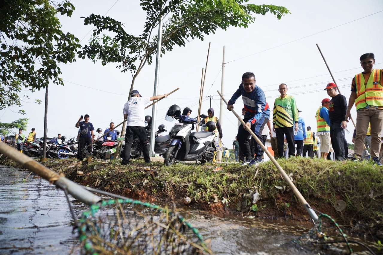 GOTONG ROYONG: Pj Wali Kota Edi Suryanto turut bergotong royong Bersama warga membersihkan parit di Jalan Pemda Pontianak Timur.