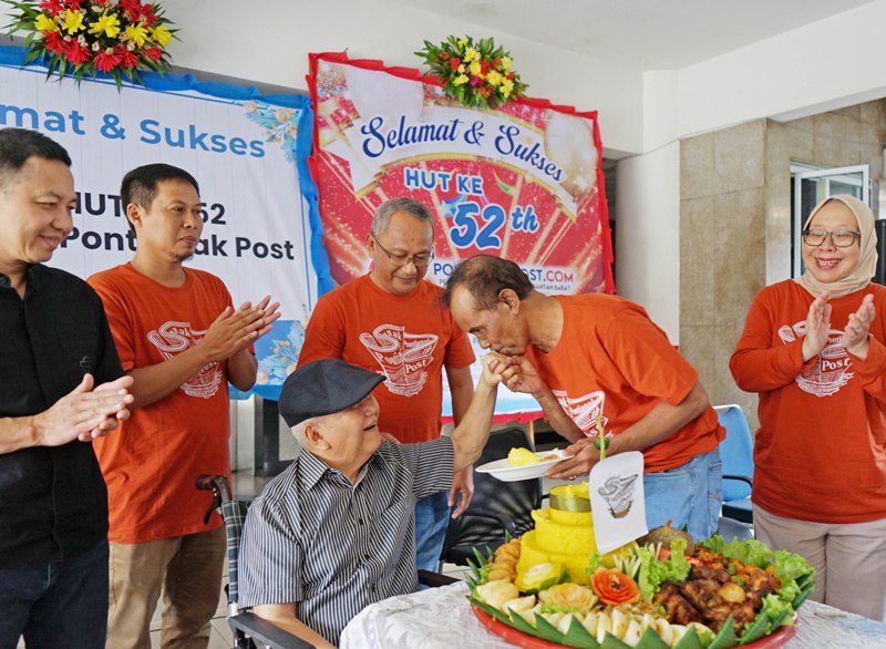 Karyawan Pontianak Post Abu Sofian memberikan potongan tumpeng ulang tahun kepada Tabrani Hadi.
