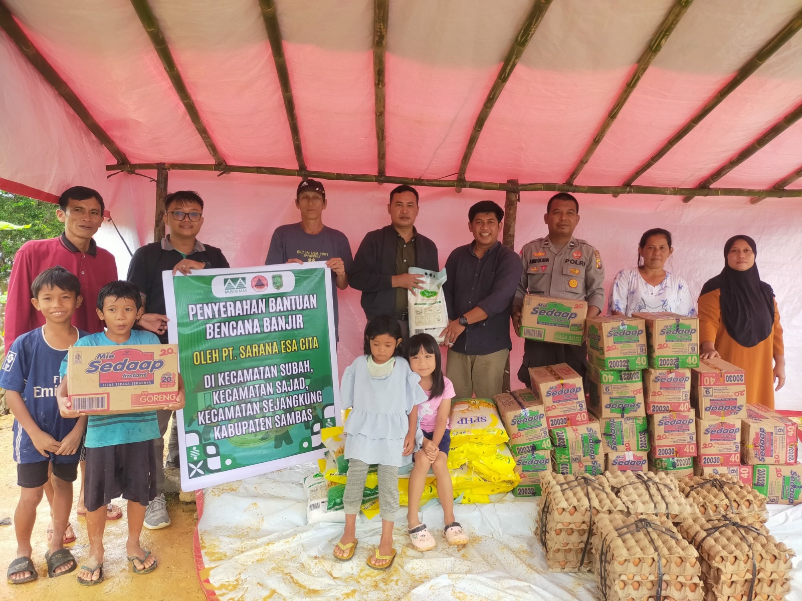 Warga korban banjir menerima bantuan berupa bahan makanan.
