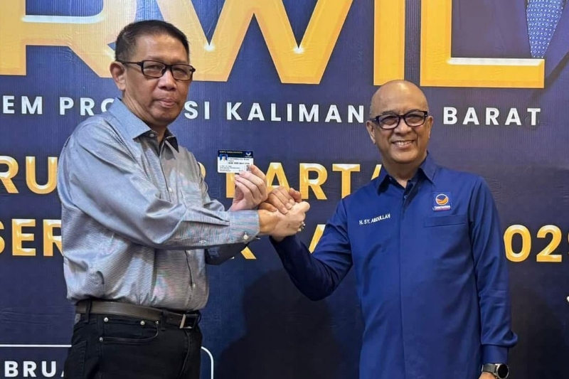 Sutarmidji menerima kartu anggota partai NasDem dari Ketua DPW NasDem Kalbar Syarif Abdullah Alkadrie di sela agenda Rakerwil Partai NasDem Kalbar, Sabtu (8/2).