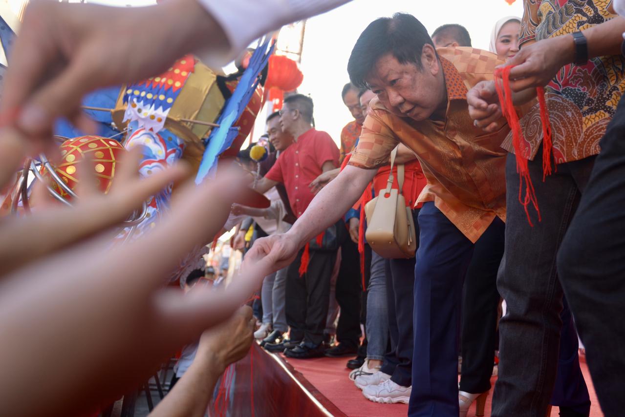 Tokoh Tionghoa sekaligus Ketua umum yayasan Pemadam Kebakaran Panca Bhakti, The Lu Sia saat membagikan jenggot naga pada prosesi ritual buka mata di Klenteng Kwan Tie Bio, Jalan Diponegoro, Pontianak.