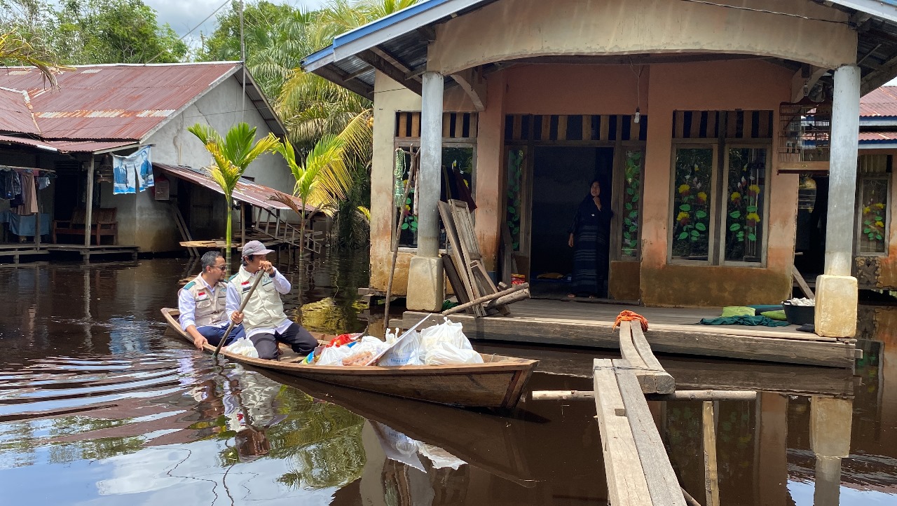Proses penyerahan bantuan dari PLN UIP KLB ke masyarakat yang terdampak banjir di Desa Kuala Mandor A, Kabupaten Kubu Raya.