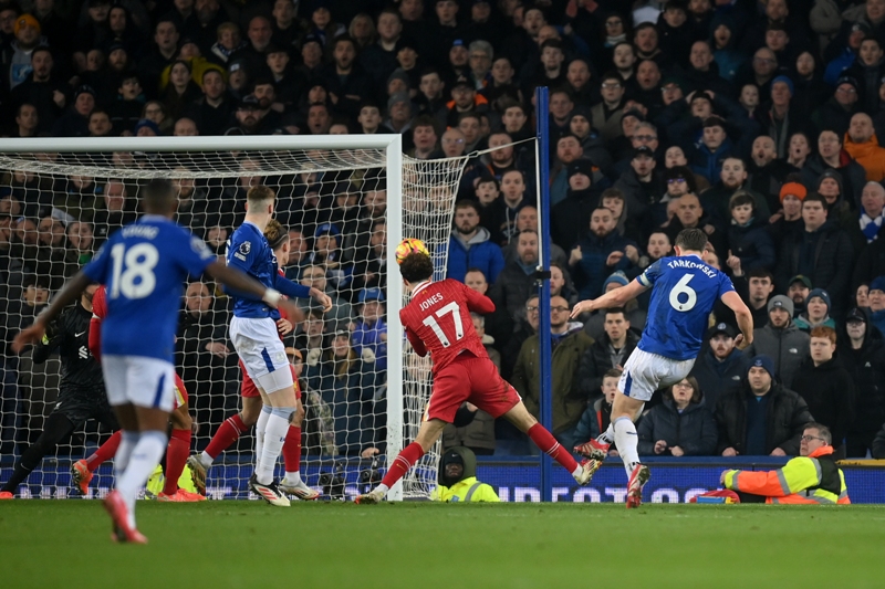 Pemain Everton James Tarkowski (nomor punggung 6) melesatkan bola ke gawang Liverpool yang memaksa laga berakhir imbang dalam pertandingan tunda pekan ke-15 Liga Inggris di Stadion Goodison Park.