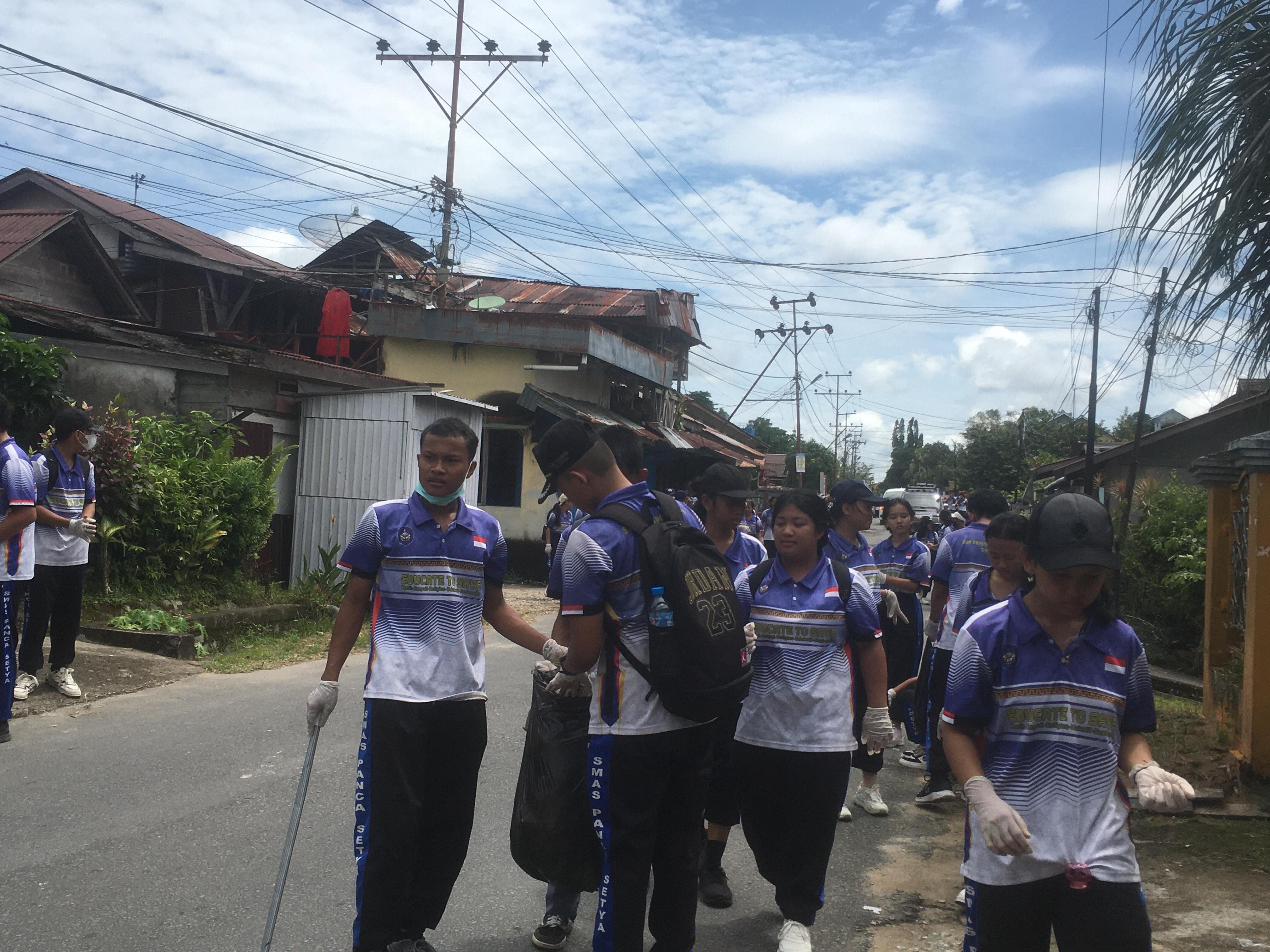 BERSIH: Ratusan siswa SMA Swasta Panca Setya Sintang saat menggelar aksi pungut sampah di Pasar Inpres.