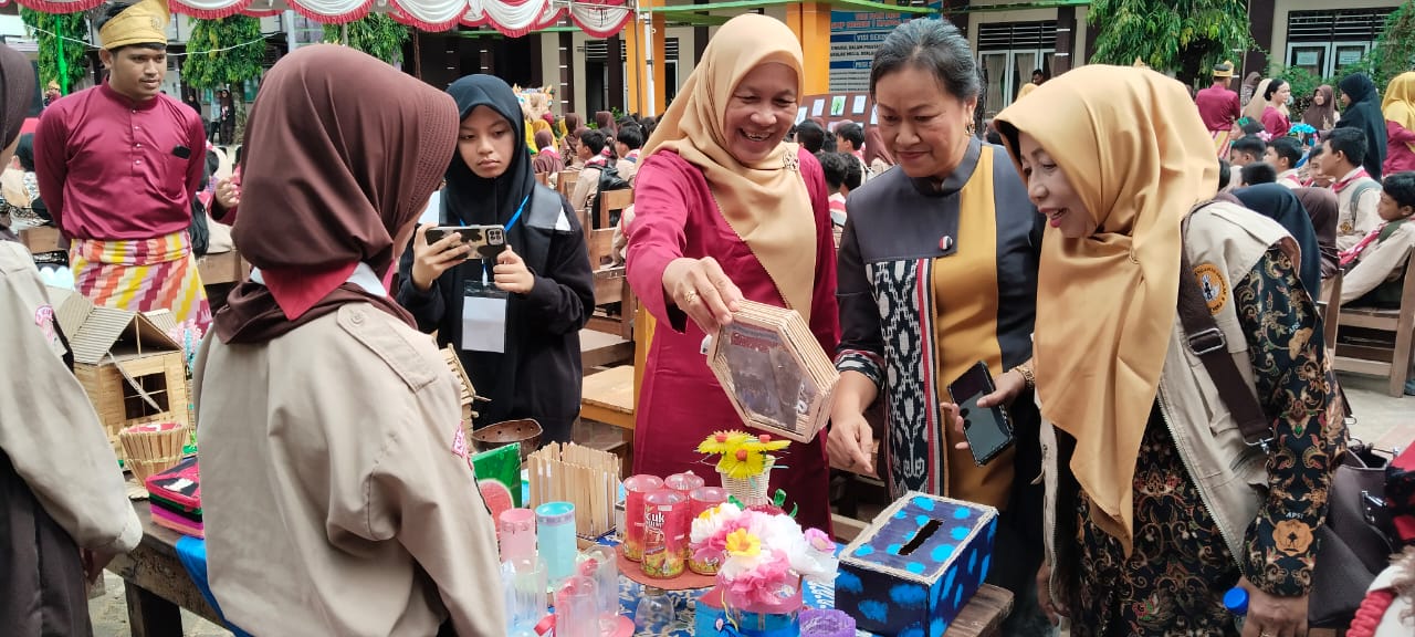 FESTIVAL: Seketaris Disdikbud Kabupaten Melawi Riani Kurniati didampingi Kepala sekolah SMPN 1 Nanga Pinoh Kherolina saat mengunjungi salah satu stan kreasi siswa dalam kegiatan Negsa Festival 2025.