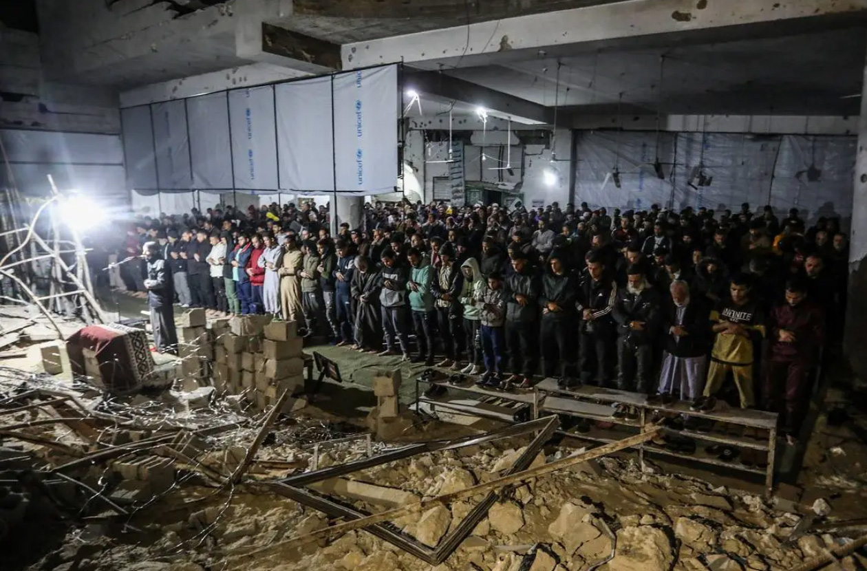 TARAWIH PERTAMA: Warga Palestina melaksanakan tarawih pertama berjemaah di antara reruntuhan Masjid Al Lebbani di Khan Younis, yang hancur akibat serangan Israel.