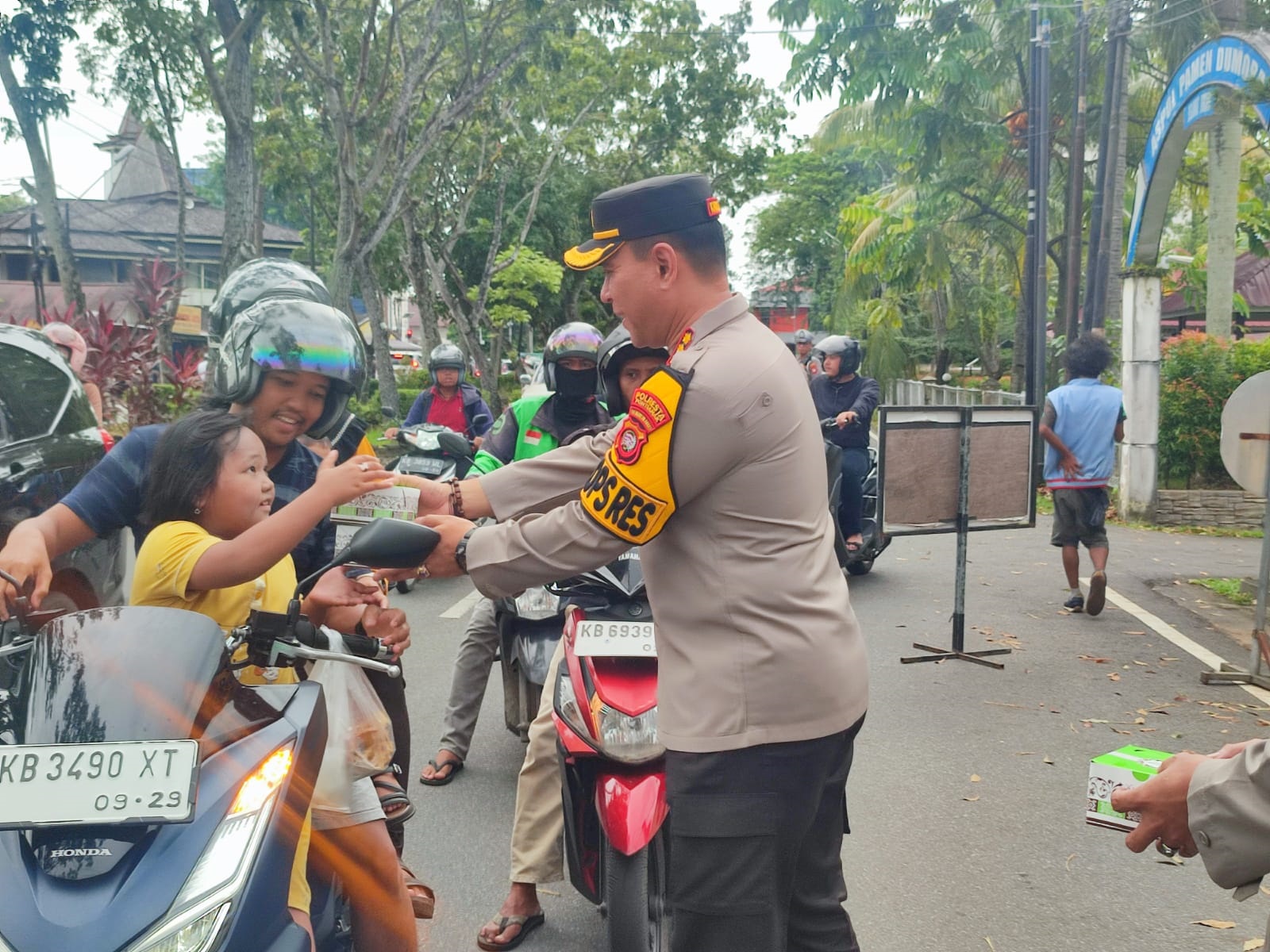 BAGI TAKJIL: Kapolresta Pontianak Kombes Pol Adhe Hariadi memberikan makanan berbuka puasa kepada pengendara motor yang melintas di depan Polresta Pontianak.