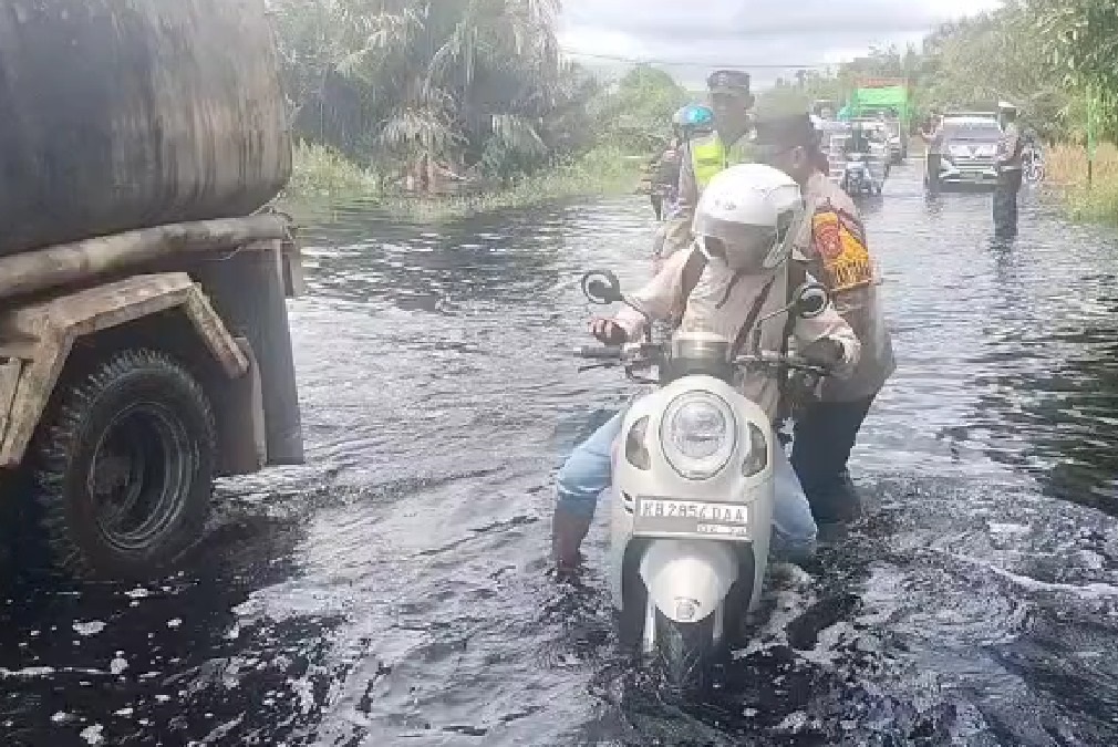 Anggota Polres Kubu Raya saat mengatur lalu lintas di lokasi banjir lokasi banjir di Jalan Trans Kalimantan.