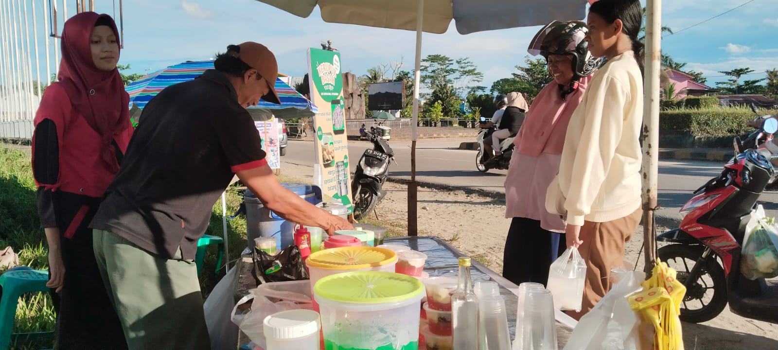 Jhoni pedagang es buah sedang melayani pelanggannya di area bundaran Tugu Juang Nanga Pinoh.