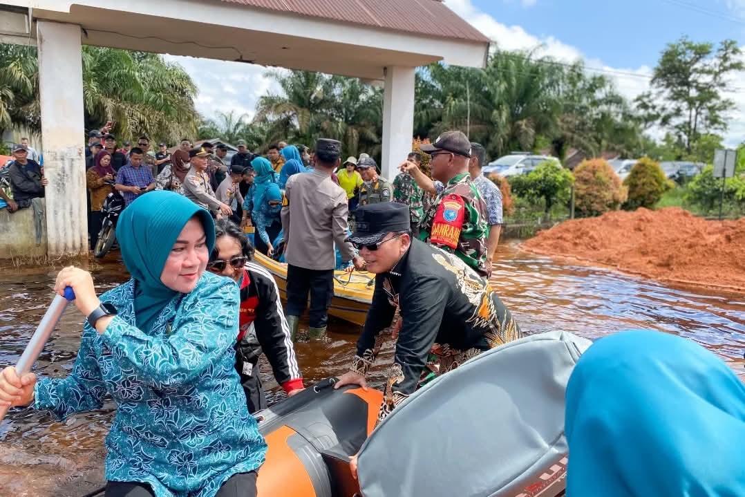 TINJAU BANJIR: Bupati Kubu Raya Sujiwo, didampingi Ketua TP PKK Atzebiyatulensi, meninjau sekaligus menyerahkan bantuan kepada masyarakat terdampak banjir di Kecamatan Sungai Ambawang.
