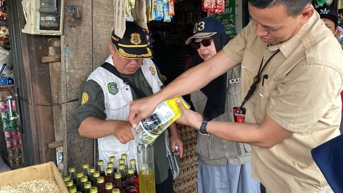 PERIKSA: Tim Gabungan saat memeriksa volume produk minyak goren Miyakita yang dijual oleh salah seorang pedagang di Kota Singkawang, belum lama ini.