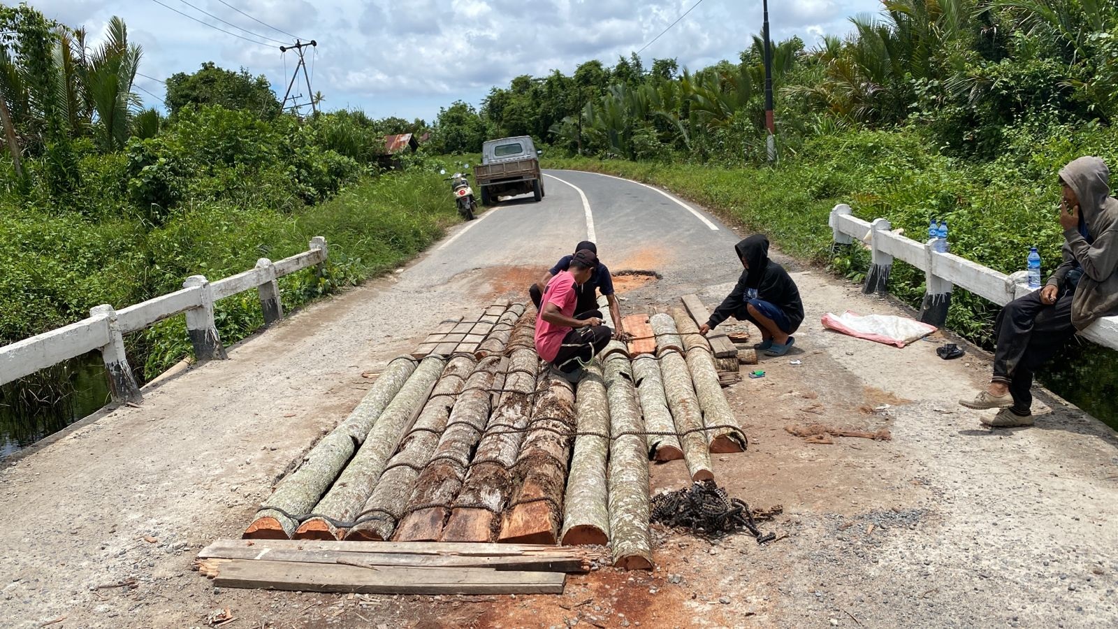 RUSAK : Kondisi jembatan di Simpang Hilir yang rusak ditutup dengan batang pohon kelapa.