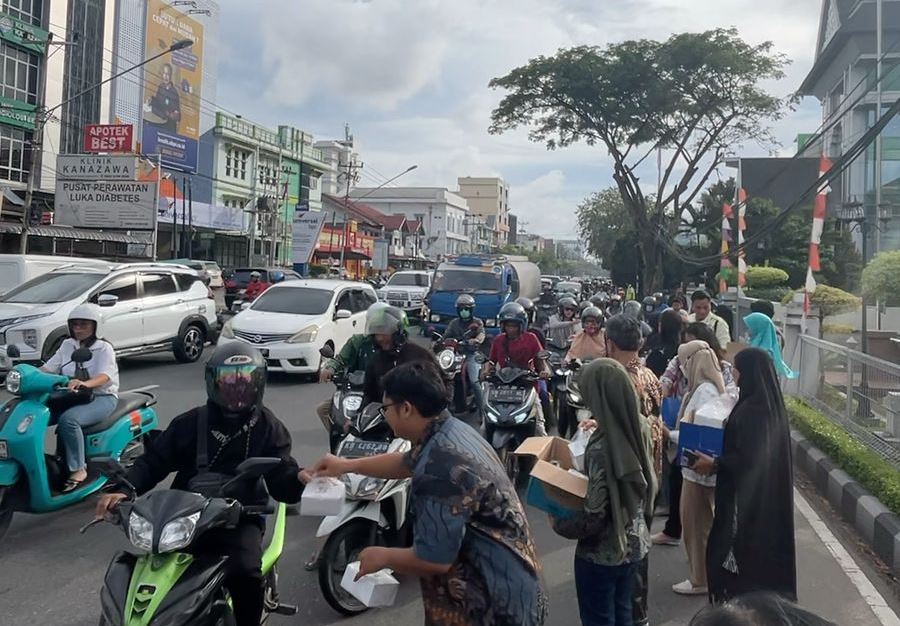 BAGIKAN : Sejumlah karyawanPTPN IV Regional V saat membagikan takjil kepada pengendara di Jalan Abdurrahman No.11, Pontianak.