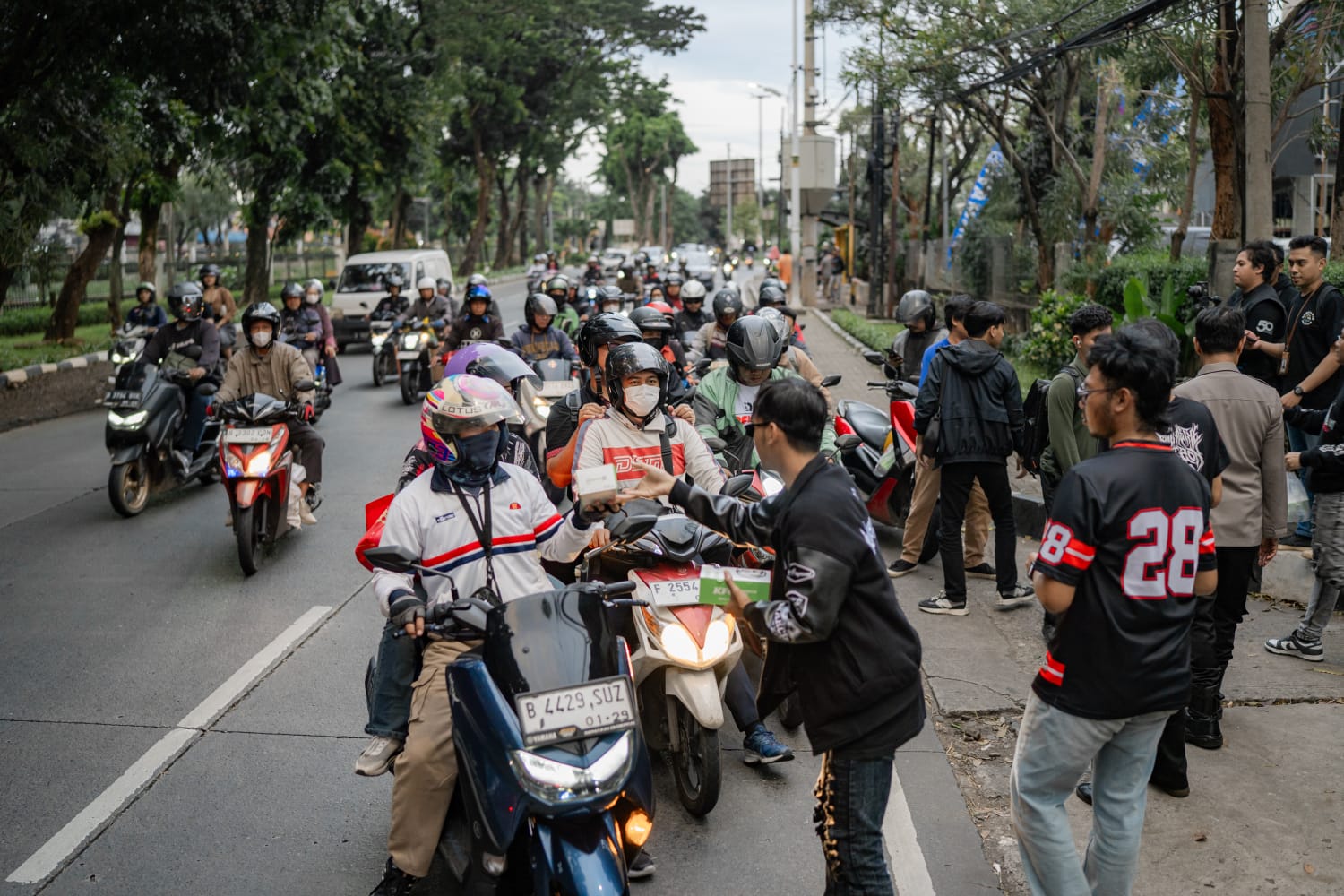 Pengguna setia Yamaha Aerox saat membagikan takjil kepada para pengguna jalan.