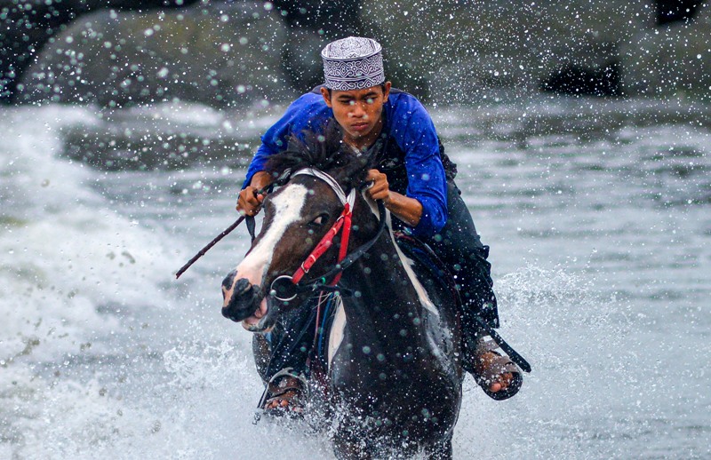Santri Pondok Pesantren Kanzul Ulum melatih kuda berpacu, di Pantai Pasia Nan Tigo Padang, Sumatera Barat.