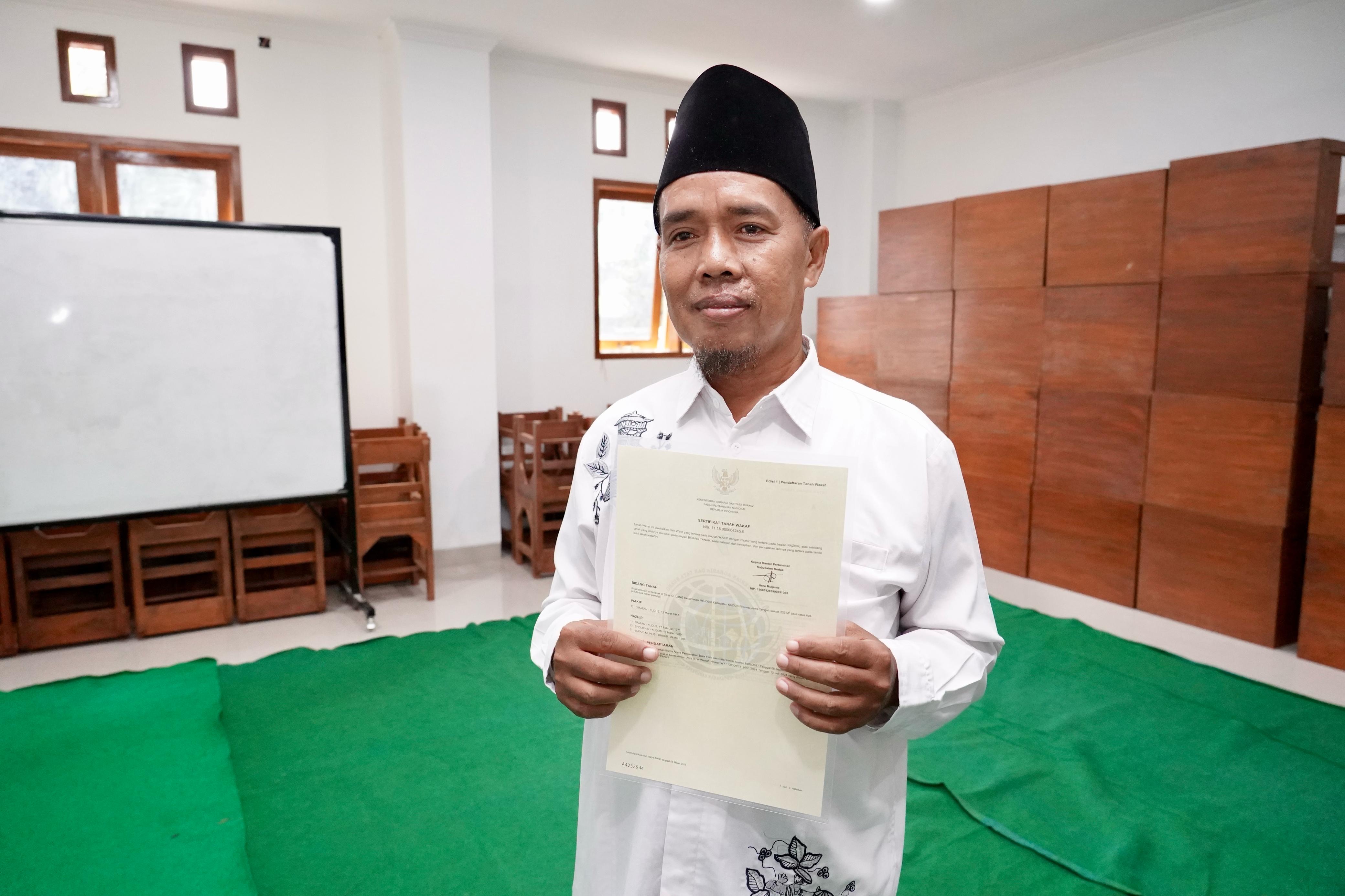 Saiman, laki-laki kelahiran Kabupaten Kudus, menerima sertipikat tanah wakaf dengan peruntukkan Makam Demangan, pada Sabtu (08/03/2025).