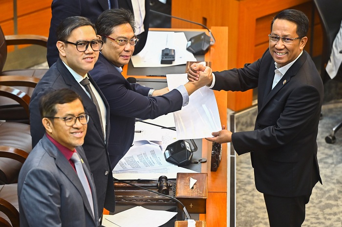 Menteri Hukum Supratman Andi Agtas (kanan) berjabat tangan dengan Ketua Komisi I DPR Utut Adianto saat rapat RUU TNI di Senayan, Jakarta, Selasa (18/3/2025). Komisi I DPR setujui pembahasan RUU TNI.