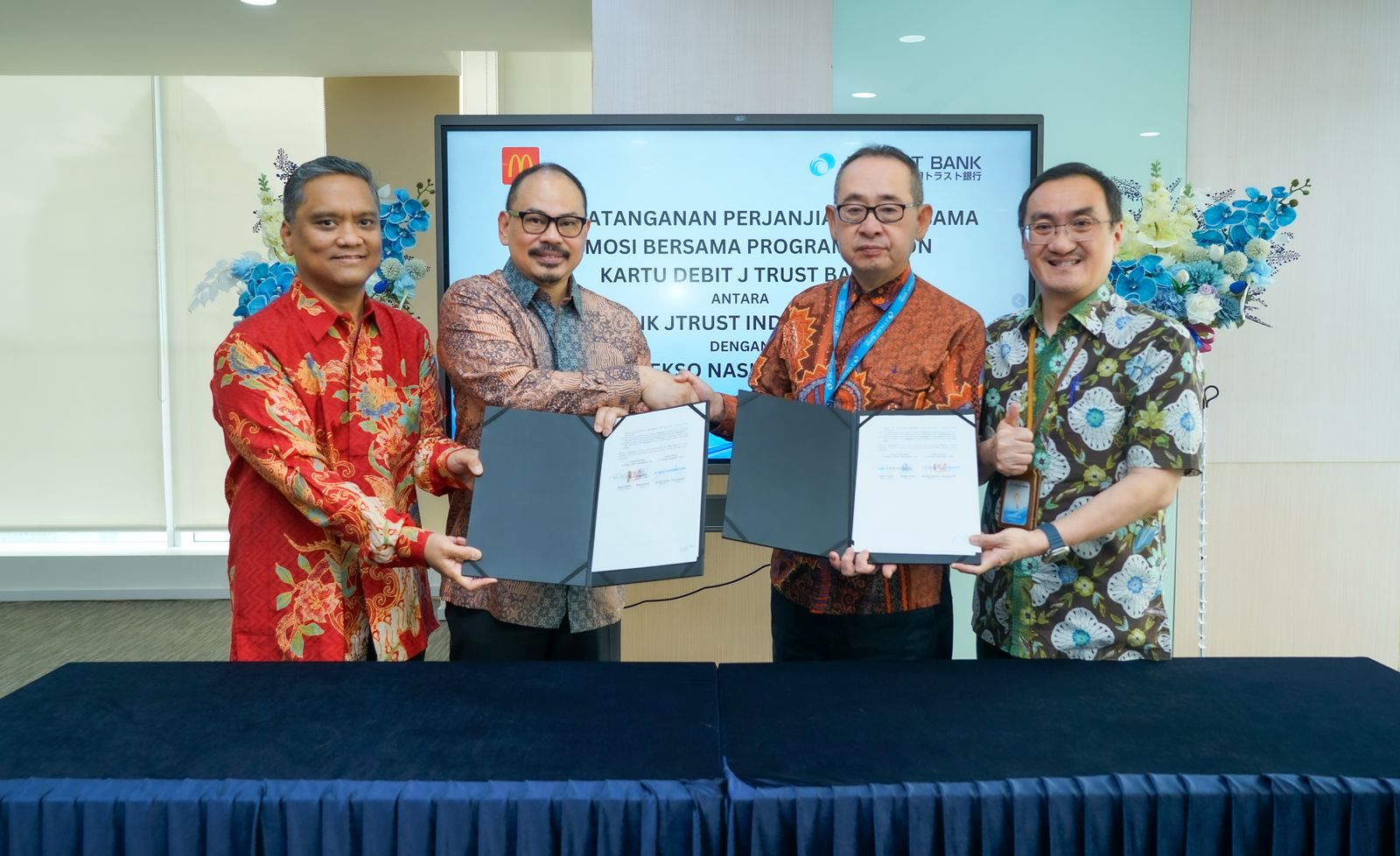 Director of Marketing Communications, CBI & Digital McDonald&rsquo;s Indonesia Michael Hartono (kedua dari kiri) berjabat tangan dengan Direktur Bisnis J Trust Bank, Widjaja Hendra usai mendatangani PKS.